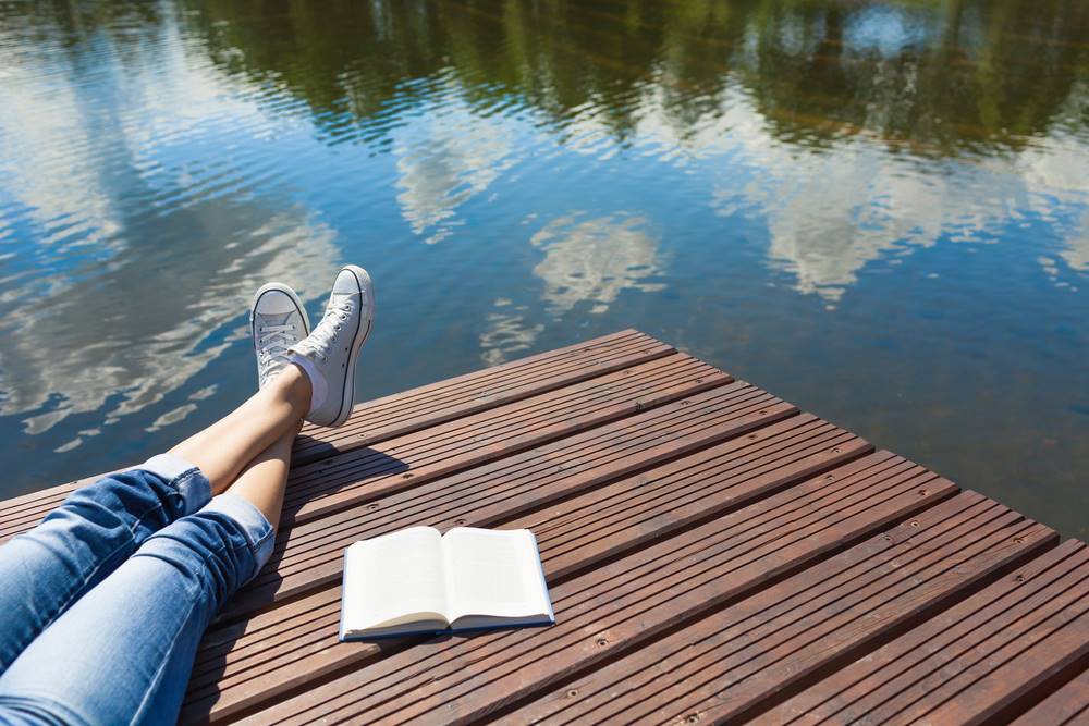 reading a book on the lake