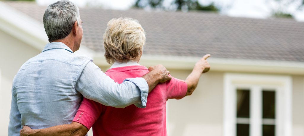 man and woman looking at house