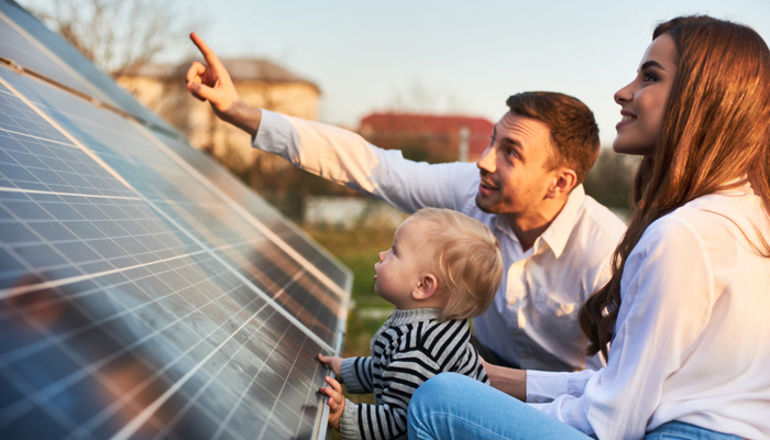 ather his family pointing to his child boy the solar panels with his wife on a warm day