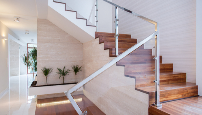Stylish stainless steel and glass staircase in bright house interior