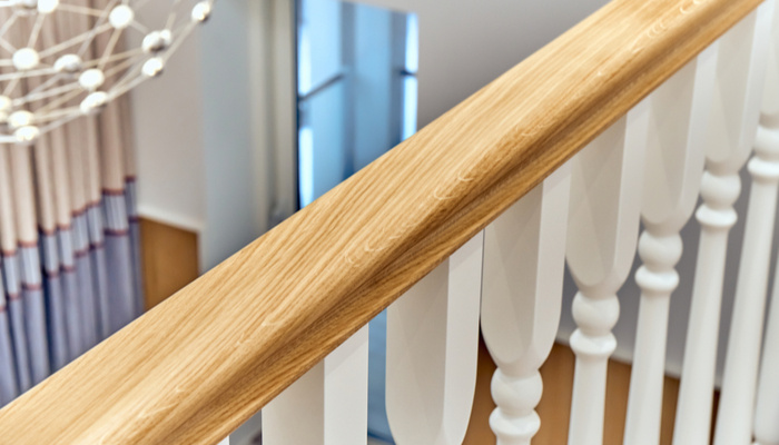 Wooden railing with white balusters in a bright large room