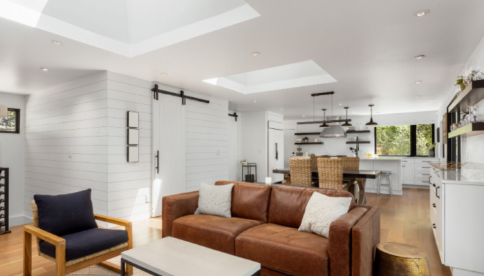 White and Bright Living Room and Kitchen in New Luxury Home featureing Large Skylights and Barn Doors