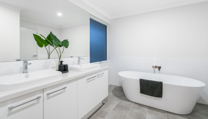 White large modern bathroom interior with high end fittings and plant and stand alone bathtub