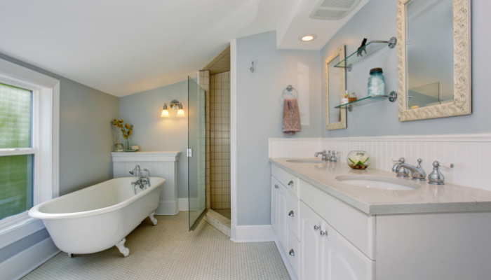 All white luxury master bathroom with vintage bathtub and tile floor and big window on the side