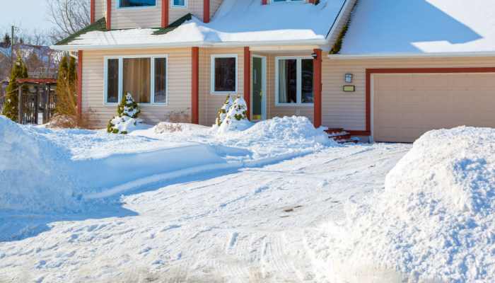 A family home with a wide yard in a suburb covered in snow