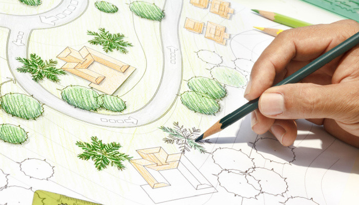 Landscape Architect holding a green colored pencil Designing on site analysis plan